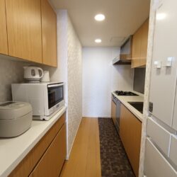 3.8帖の独立したキッチンスペース　背面に収納棚・上部吊戸棚付きキッチン